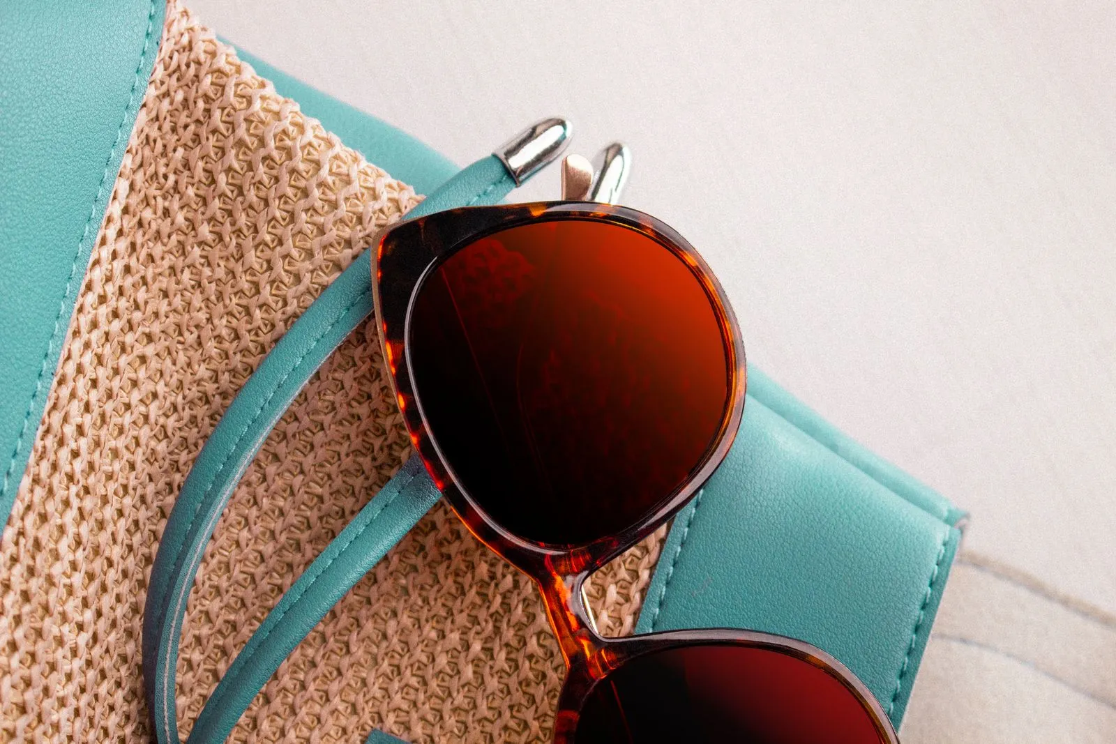 Fashionable sunglasses on a straw bag, perfect for summer styles.